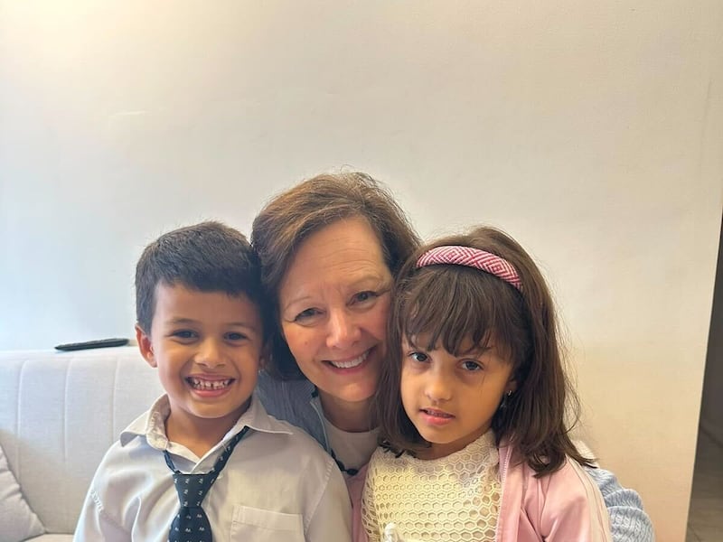 Presidenta General de la Primaria Susan H. Porter, centro, se toma una foto con dos niños en Brasil, sábado, 13 de junio de 2026.