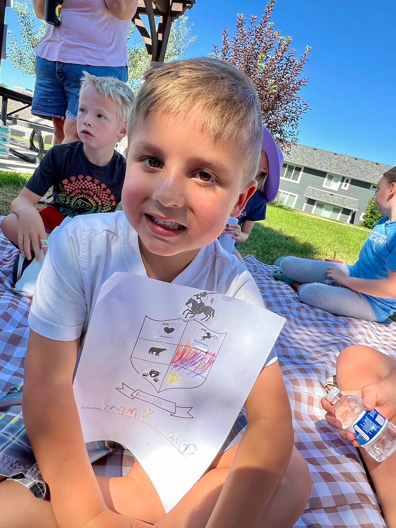 Benjamin Trujillo, de 5 años, dibuja un escudo con símbolos sobre su familia durante un campamento de verano de historia familiar el 14 de julio de 2025.