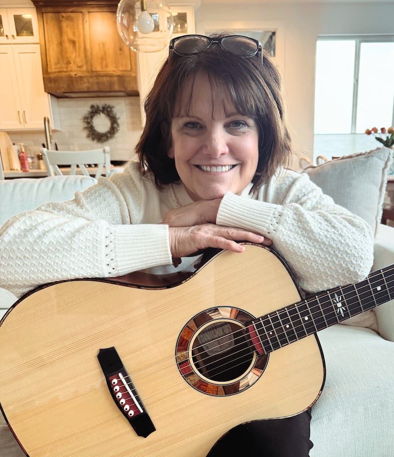 Shawna Edwards — compositora de "The Miracle", una nueva adición a Hymns for Home and Church — posa para una foto con una guitarra en Lehi, Utah, en enero de 2025.