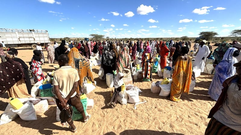 Grupos de aldeanos se paran junto a sus pilas de suministros de ayuda y alimentos proporcionados por la Iglesia y el Foro Nacional de Líderes Musulmanes en Korr, Kenia, 29 de mayo de 2026.