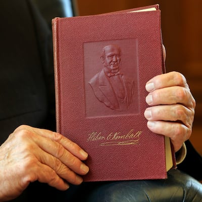 El élder Quentin L. Cook, del Cuórum de los Doce Apóstoles de La Iglesia de Jesucristo de los Santos de los Últimos Días, sentado en su oficina en el Edificio Administrativo de la Iglesia en Salt Lake City, el miércoles 24 de junio de 2020, sostiene un libro titulado Heber C. Kimball, al que hizo referencia en su discurso del Seminario de Liderazgo Misional 2020.