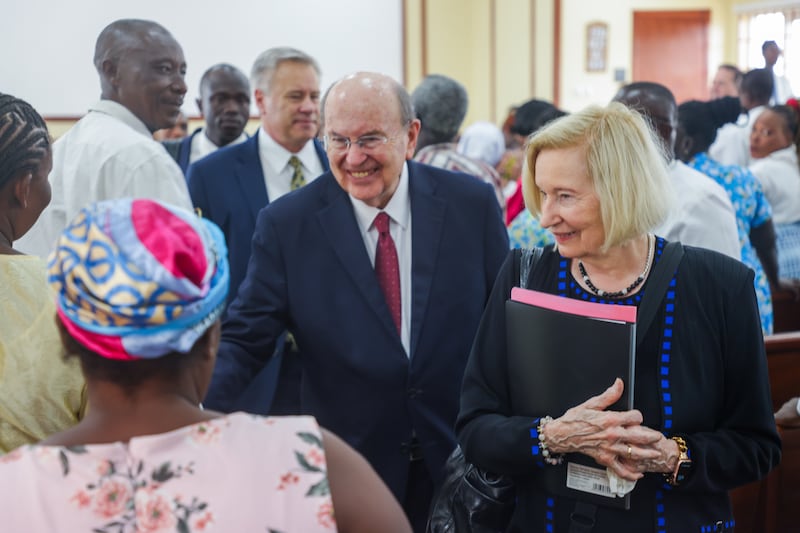 El élder Quentin L. Cook y la hermana Mary Cook saludan a los miembros del Barrio Jamestown en Acra, Ghana, antes del inicio de la reunión sacramental el 15 de febrero de 2026.