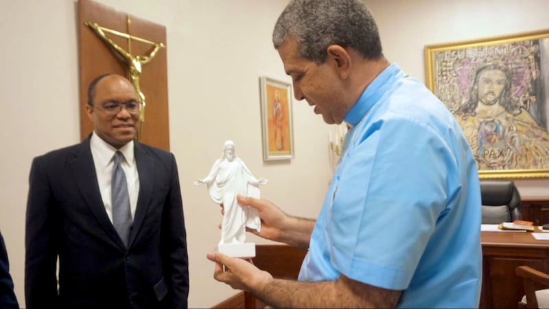 El élder Ahmad S. Corbitt entrega al monseñor Carlos Tomás Morel Diplán una pequeña réplica de la estatua del Cristo.