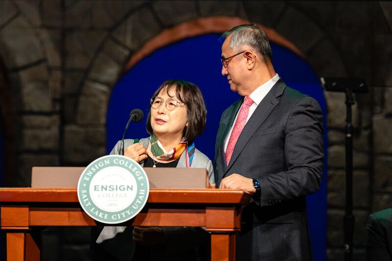 La hermana Bon Kyung Koo Choi se une a su esposo, el élder Yoon Hwan Choi, Setenta Autoridad General, en el púlpito durante un devocional de Ensign College realizado en el Teatro del Centro de Conferencias en el centro de Salt Lake City, el martes 19 de noviembre de 2024.
