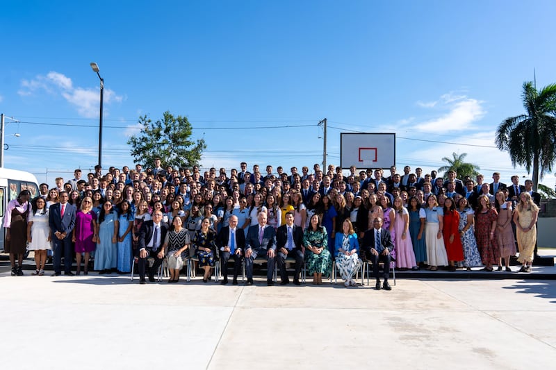 El élder Ronald A. Rasband, del Cuórum de los Doce Apóstoles, y otros líderes posan para una foto con misioneros que prestan servicio en la República Dominicana.