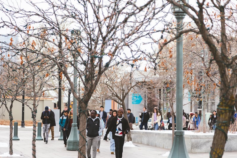 A group of students walks outside the Conference Center, with snow on the ground.
