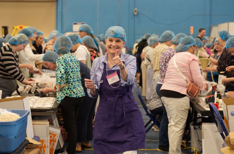 Mujeres empacan comidas para Hunger Fight durante la Noche de Servicio en la Conferencia de Mujeres de BYU 2024.