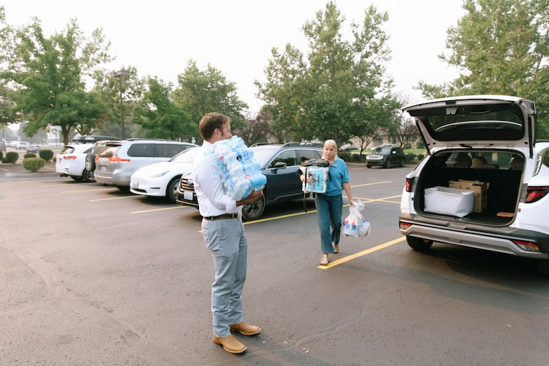 Miembros de la Estaca Spokane Washington llevan suministros al centro de estaca para las personas afectadas por los incendios forestales en Spokane, Washington, el 2 de agosto de 2026.