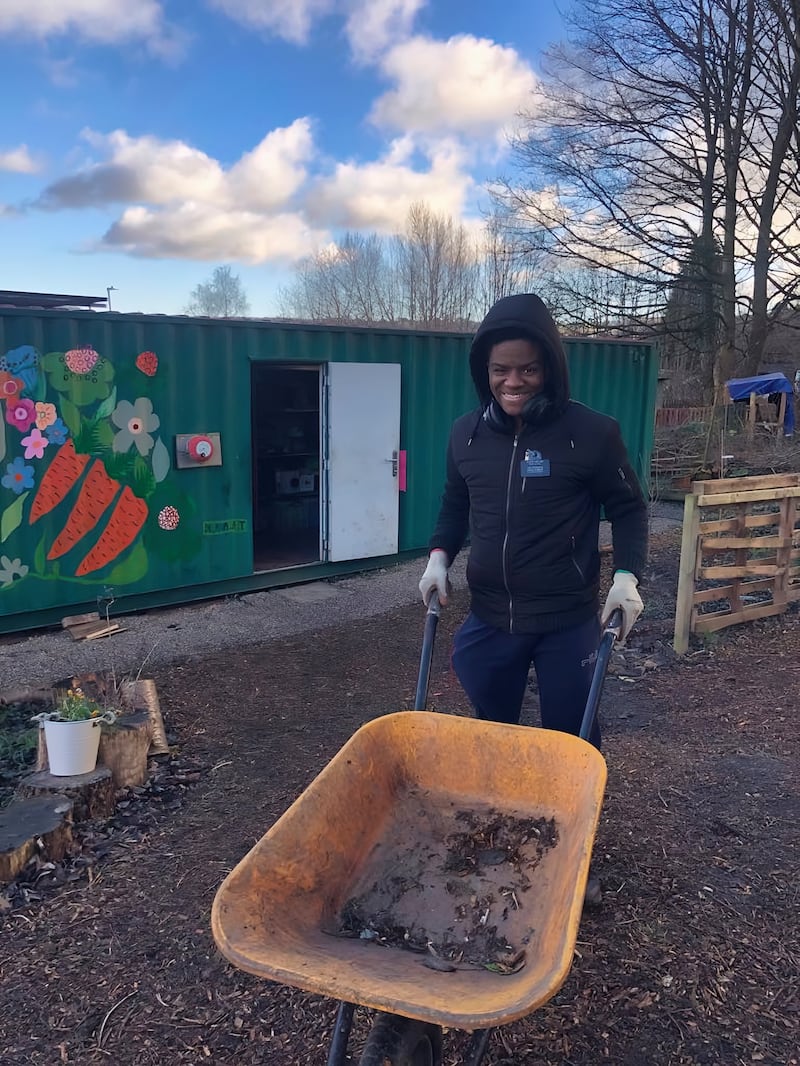 El élder Daniel Miller sirve en el jardín comunitario en Huddersfield, Inglaterra, en 2025.