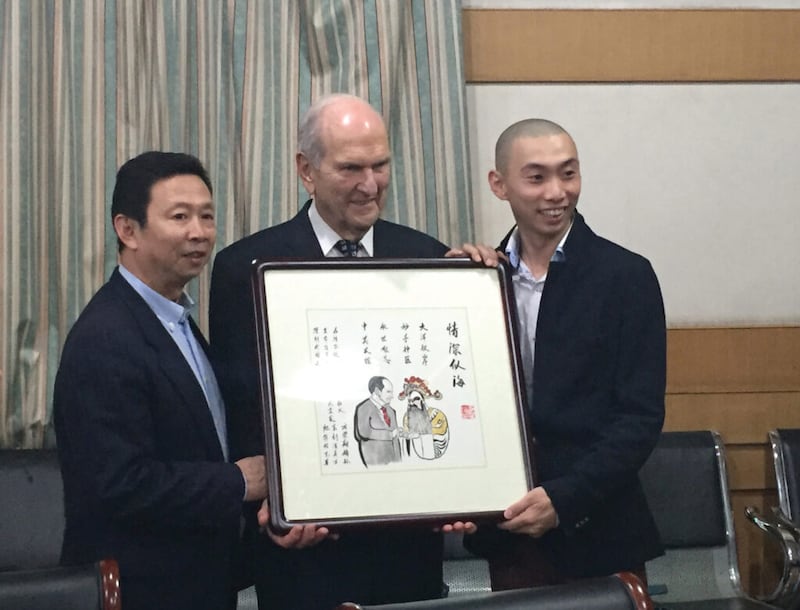 El presidente Russell M. Nelson recibe un homenaje en octubre de 2015 de parte del hijo y el nieto de Fang Rongxiang, la estrella de ópera china cuya vida él salvó con una cirugía de corazón.