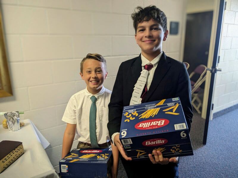 Isaac Wright y Jace Eddy llevan cajas de pasta al centro de reuniones para una colecta de alimentos en Broken Arrow, Oklahoma, el 10 de septiembre de 2023. Los voluntarios de SirveAhora y miembros de la Estaca Broken Arrow, Oklahoma donaron alimentos para la organización Broken Arrow Neighbors.