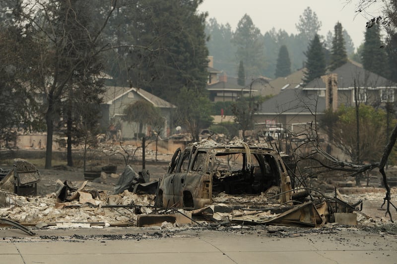 Un vehículo y una estructura se queman en North Skyline Drive debido a un incendio forestal, domingo 2 de agosto de 2026, en Spokane, Washington.