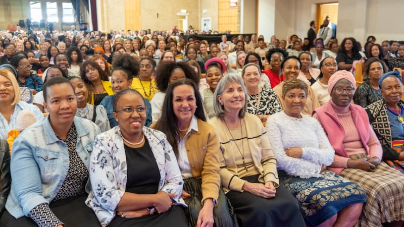 La hermana J. Anette Dennis y la hermana Keala Sikahema se sientan en la primera fila de una gran reunión de mujeres para una devocional para mujeres celebrada en Johannesburgo, Sudáfrica, el domingo 7 de septiembre de 2025.