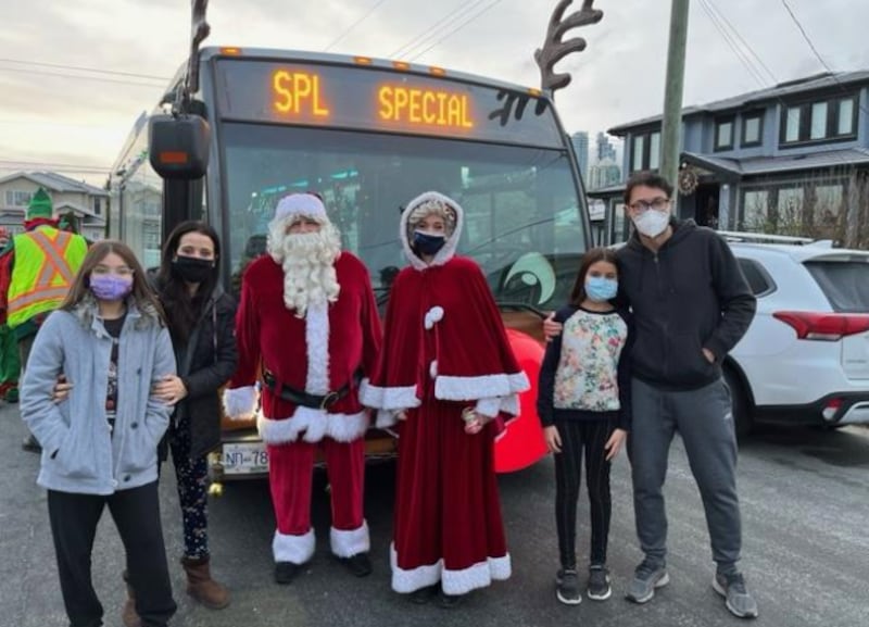 La familia Venditti, de la Estaca Vancouver, Columbia Británica, posa para una foto con Papá Noel y la Sra. Claus frente al autobús decorado como un reno de TransLink en diciembre de 2021. El coordinador de SirveAhora, Bruno Venditti, usó SirveAhora.org para promover el proyecto y permitir que más juguetes fueran recaudados.