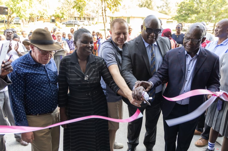 Martin Evans — segundo consejero en la presidencia del Distrito Kisumu, Kenia, al centro — corta la cinta del nuevo centro de aprendizaje para la Escuela Secundaria Especial Kibos junto con otros líderes comunitarios en Kisumu, Kenia, el 16 de enero de 2026.