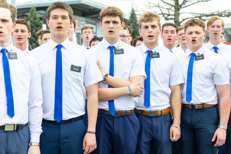 Los misioneros de la Misión Misuri Independencia se preparan antes de cantar el himno nacional en el juego de los Kansas City Royals, el jueves 9 de abril de 2026.