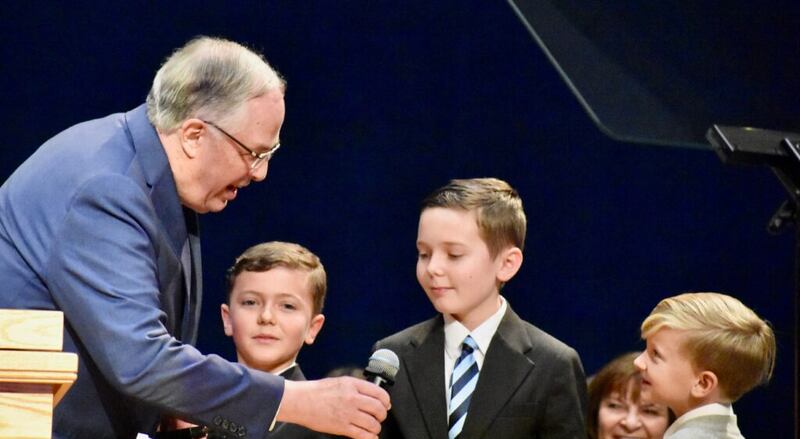 El élder Neil L. Andersen junto a varios de sus nietos durante un devocional del Día de Acción de Gracias en el Centro de Capacitación Misional de Provo, el 28 de noviembre de 2019, en Provo, Utah.