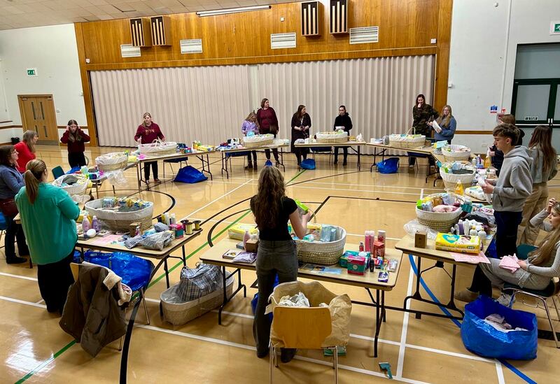 Jóvenes de la Estaca Northampton Inglaterra preparan canastas con artículos para bebés para entregar a nuevas mamás durante una actividad de servicio en octubre de 2024.