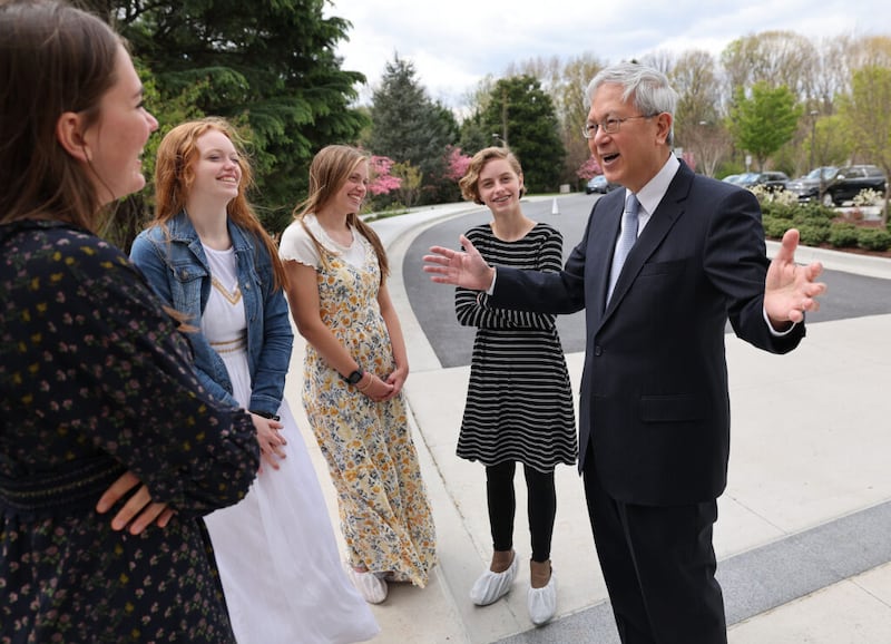 El élder Gerrit W. Gong, miembro del Cuórum de los Doce Apóstoles de la Iglesia de Jesucristo de los Santos de los Últimos Días, a la derecha, habla con Anna Little y Audrey, Ginny y Lily Bastian después de darles un recorrido por el Templo de Washington D.C. en Kensington, Maryland, el martes 19 de abril de 2022.