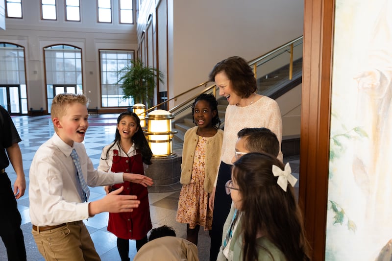 La presidenta Susan H. Porter conversa con niños en el Centro de Conferencias en Salt Lake City durante una pausa en la grabación de Amigo a Amigo de mayo de 2026.