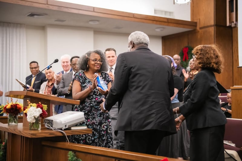 Sabra Stewart-Johnson entrega a Vernon y Linda James un reconocimiento por servicio por toda su labor con el Fort Worth Save Our Children Learning Center durante el devocional Santos en Unidad en Fort Worth, Texas, el 16 de noviembre de 2025.