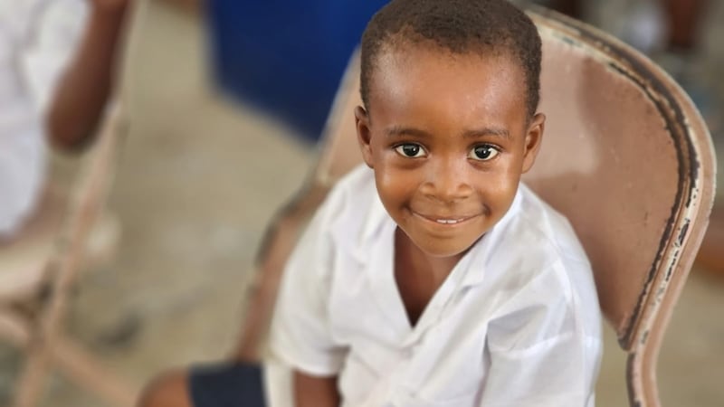 Un niño sonríe durante la ceremonia que marcó la donación de nuevas aulas y suministros en una escuela primaria en el condado de Lower Margibi, Liberia, el 21 de febrero de 2026.