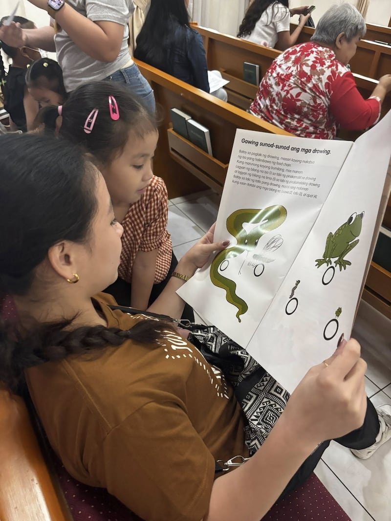 Una madre y su hijo leen un libro sobre nutrición durante la primera evaluación del Programa de Nutrición Infantil realizada en el Centro de Estaca Caloocan Filipinas el 24 de enero de 2026.