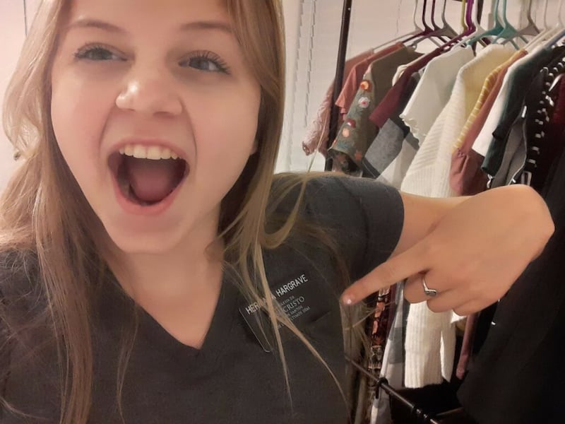 La hermana Hannah Hargrave, una misionera nueva que se está entrenando en su propio hogar en San Tan Valley, Arizona, señala su credencial en su cuarto en marzo de 2020.