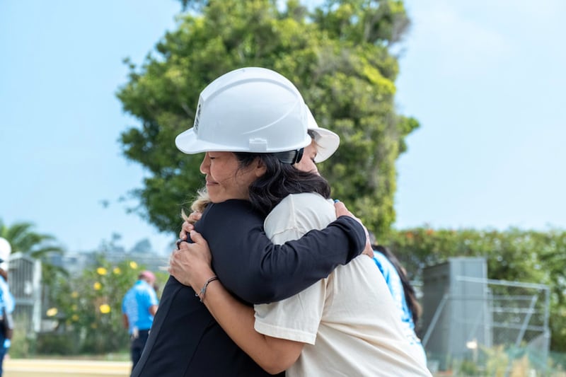 Los voluntarios se abrazan durante un esfuerzo de Hábitat para la Humanidad para reconstruir hogares destruidos durante el Incendio de Palisades durante un evento de cuatro días en septiembre de 2026 en Los Ángeles, California.