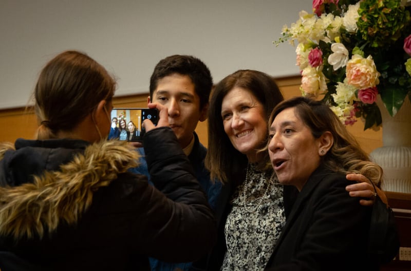 La hermana Michelle D. Craig, primera consejera de la presidencia general de las Mujeres Jóvenes, se toma una foto con miembros de la Iglesia durante un devocional para jóvenes el 12 de marzo de 2022 en Madrid, España.