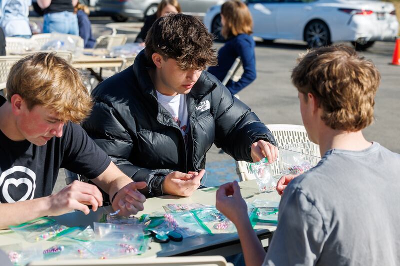 Tres estudiantes de secundaria arman pulseras durante un proyecto de servicio en Meridian, Idaho, el viernes 27 de febrero de 2026.