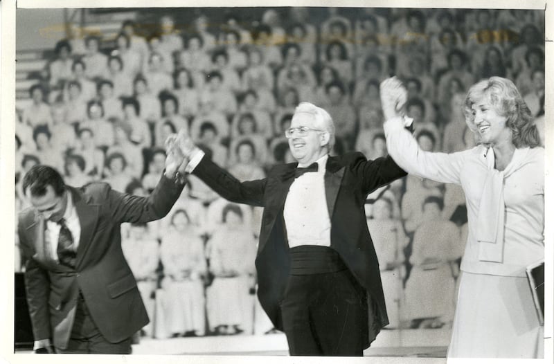 Lin de Paula, a la izquierda, y Wany Santos Thrikill, a la derecha, son miembros del coro de Brasil. Jerold D. Ottley, director, los presenta al público durante los conciertos del Coro del Tabernáculo de la Manzana del Templo en São Paulo, Brasil, en mayo de 1981.