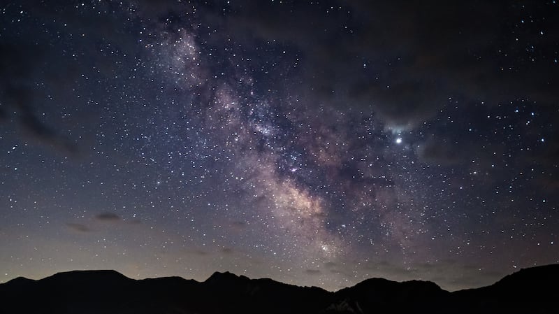 La Vía Láctea se ve sobre las cimas de las montañas.