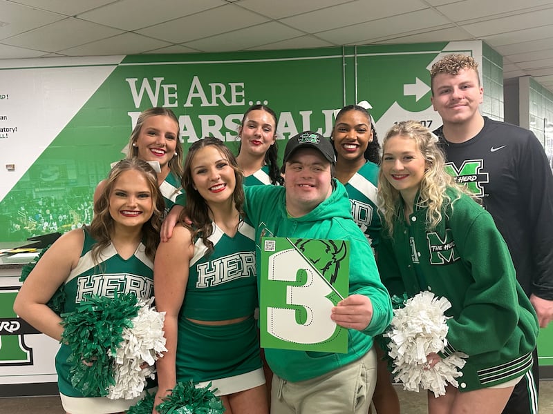 El élder Welch sonríe con un grupo de porristas en_______ en Huntington, Virginia Occidental.