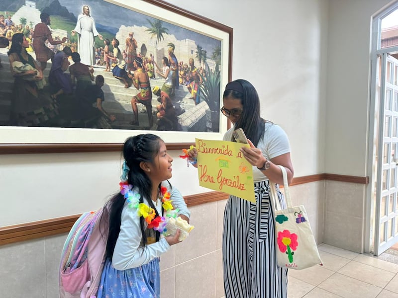 Un miembro de la familia da la bienvenida a una niña de la Primaria que regresa de su misión simulada, después de la actividad del centro de capacitación misional en miniatura de la Primaria de la Estaca Samborondón, Ecuador, en Guayaquil, Ecuador, el 21 de febrero de 2026.