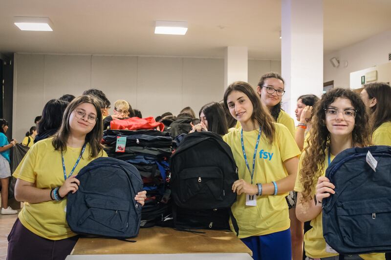 Jóvenes que asisten a FSY posan con mochilas de útiles escolares que están organizando para donar a niños necesitados en Grosetto, Italia, el 30 de julio de 2025.