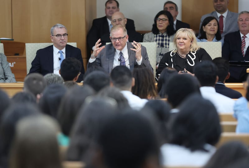 El élder Gary E. Stevenson, del Cuórum de los Doce Apóstoles, su esposa, la hermana Lesa Stevenson, y el élder Carlos A. Godoy hablan con los asistentes durante un devocional para jóvenes en el centro de estaca de los terrenos del templo en Río de Janeiro, Brasil, el sábado 7 de mayo de 2022.