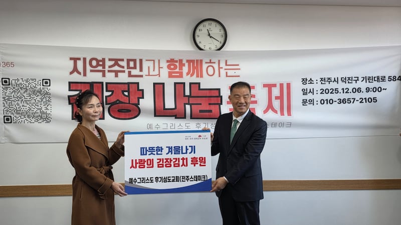 El élder Christopher H. Kim sonríe para una foto con un miembro del Departamento de Servicios Humanitarios de la Ciudad de Jeonju, en Jeonju, Corea del Sur, el 6 de diciembre de 2025.