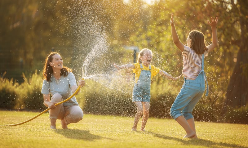 Una madre juega afuera con sus hijas.