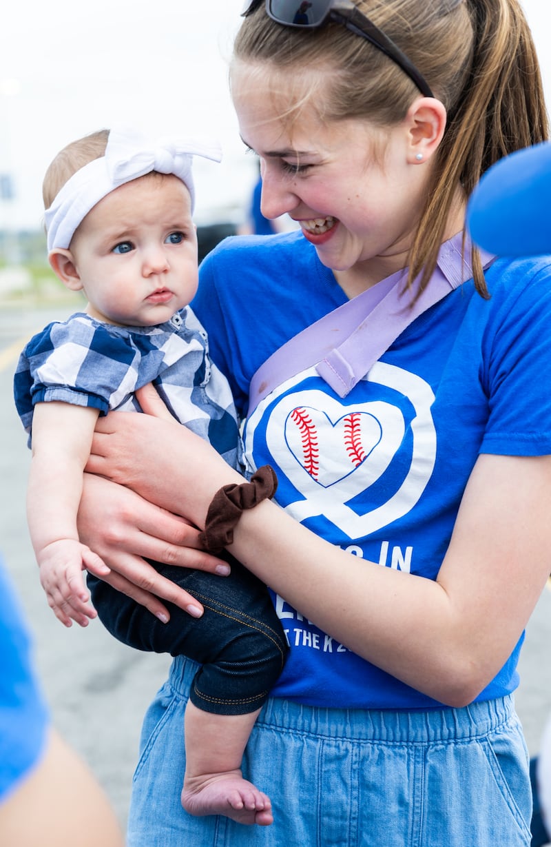 Una voluntaria hace una pausa para tomarse una foto con su hermanita en una noche de JustServe en el juego de los Kansas City Royals en Kansas City, Misuri, el 9 de abril de 2026.