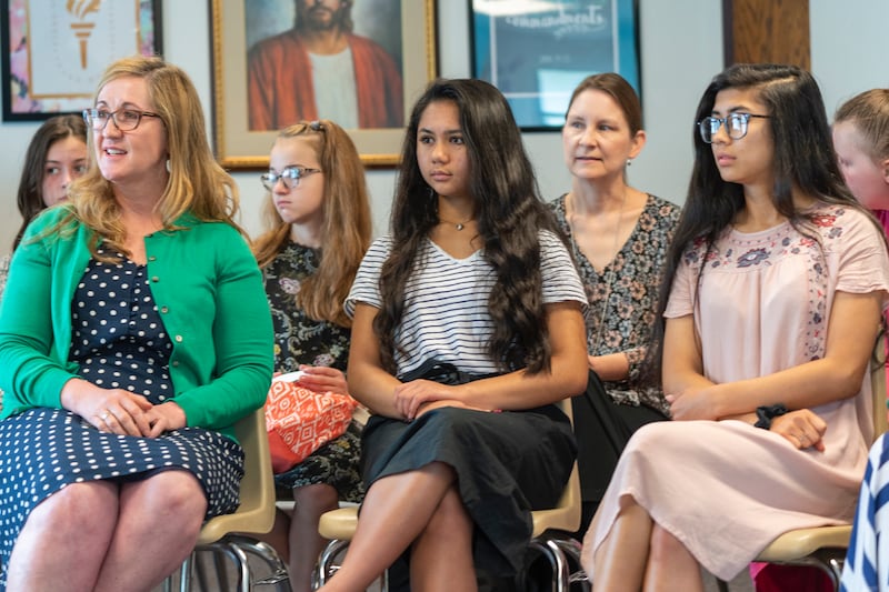 Las mujeres jóvenes escuchan durante una lección el domingo.