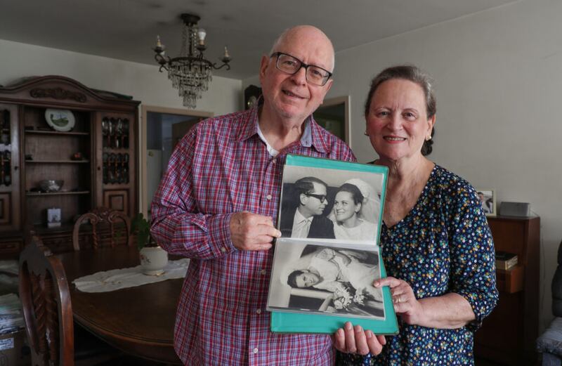 Demar y Sandra Staniscia posan para una foto con fotos de su boda en su apartamento en São Paulo, Brasil, el miércoles, 23 de mayo de 2018.