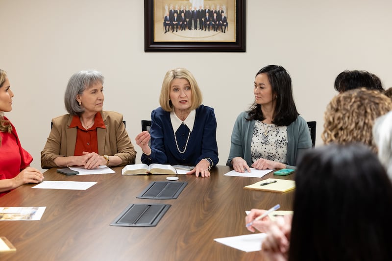 La presidenta Camille N. Johnson se sienta con sus consejeras al frente de una mesa y habla con las miembros del Consejo Asesor General de la Sociedad de Socorro.