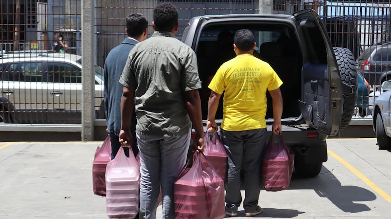Voluntarios de La Iglesia de Jesucristo de los Santos de los Últimos Días llevan comidas preparadas para ser entregadas a los necesitados el 1 de julio de 2026 en La Guaira, Venezuela.