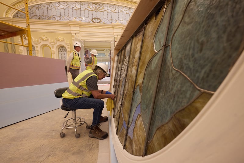 Durante la instalación, un trabajador limpia una pieza de vidrio artístico que representa a Adán y Eva, el martes 21 de abril de 2026, en Salt Lake City. La obra estará en el salón celestial del Templo de Salt Lake.