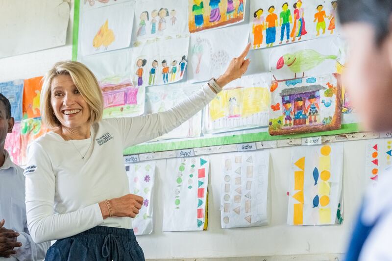 La Presidenta General de la Sociedad de Socorro, Camille N. Johnson, señala una imagen en la pared de un aula en Sri Lanka.