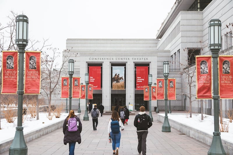 Ensign College students walk outside the Conference Center, with snow on the ground.