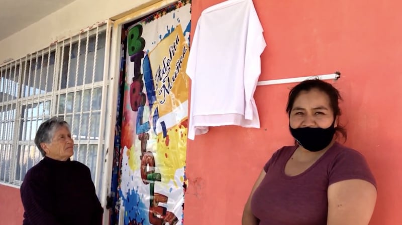 Madre e hija afuera de la biblioteca que ellas restauraron en una escuela rural en México.