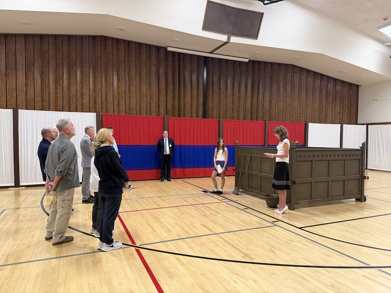 Dos jóvenes mujeres Santos de los Últimos Días explican acerca del altar de sacrificio a un grupo de visitantes en la réplica del patio del tabernáculo en la Estaca Farmington Norte de Utah, el 18 de junio de 2026.