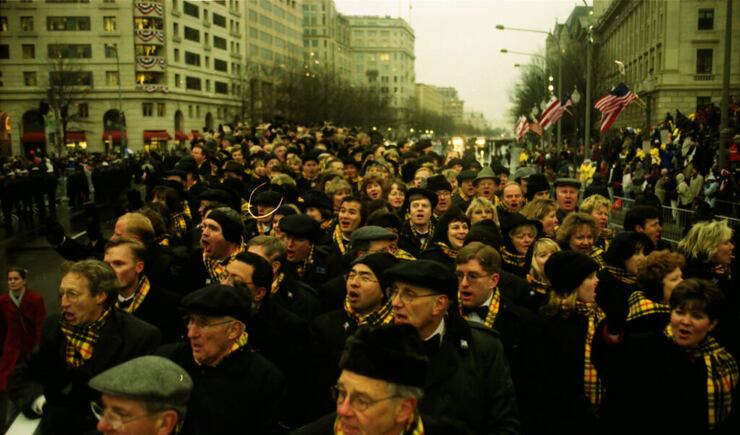 Tabernacle Choir at Temple Square members in dark coats with yellow and red plaid scarves sing as they walk in the parade for President George W. Bush's inauguration in 2001.